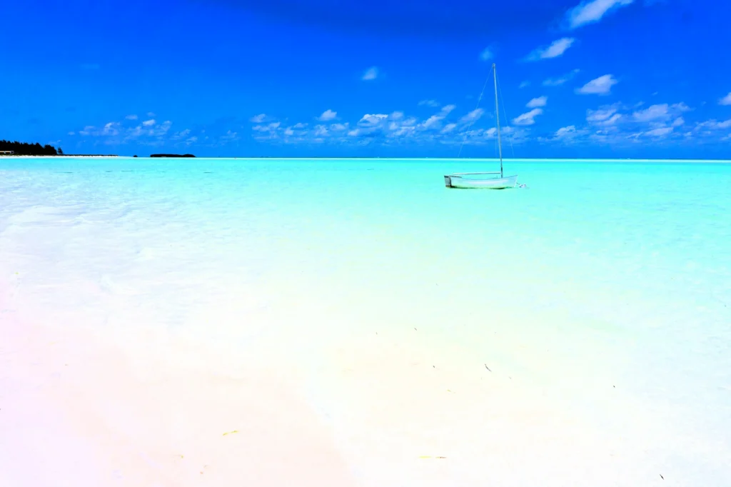 Luxury yacht cruising near Harbour Island, Bahamas, with sparkling turquoise waters, iconic pink sand beaches, and lush tropical scenery.