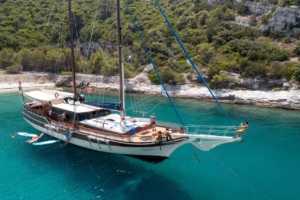 Traditional wooden gulet sailing through clear blue waters along the Turkish and Greek coastlines, with sun-soaked decks and scenic views
