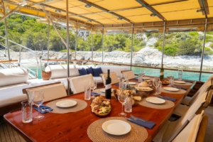 Traditional wooden gulet sailing through clear blue waters along the Turkish and Greek coastlines, with sun-soaked decks and scenic views.
