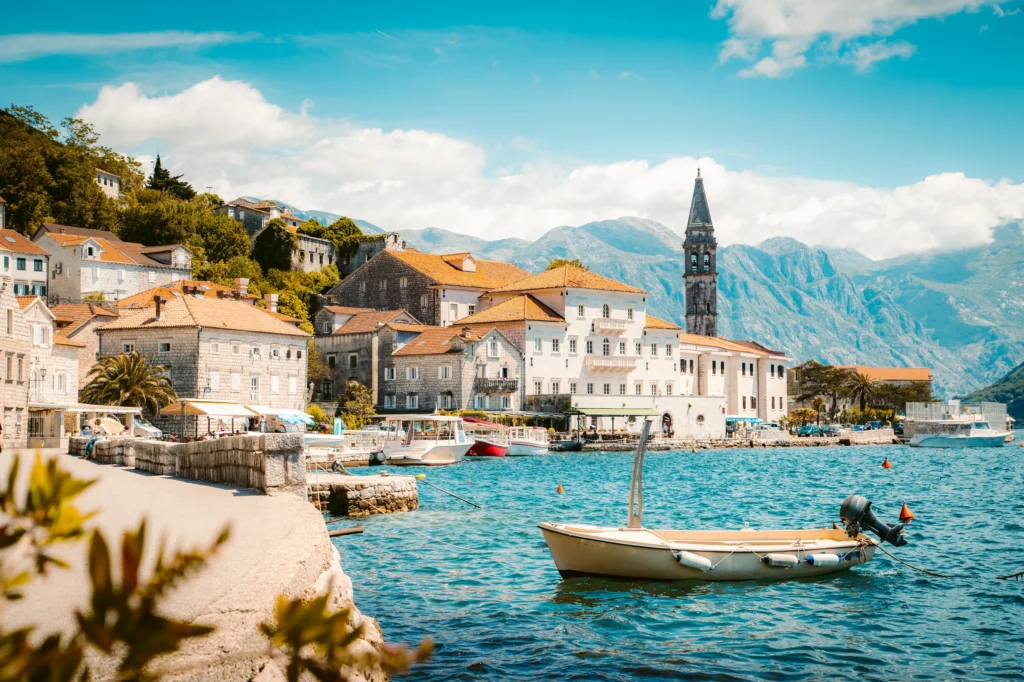 Luxury yacht cruising near Kotor, Montenegro, with dramatic Adriatic bay views, medieval town walls, and a picturesque coastline.