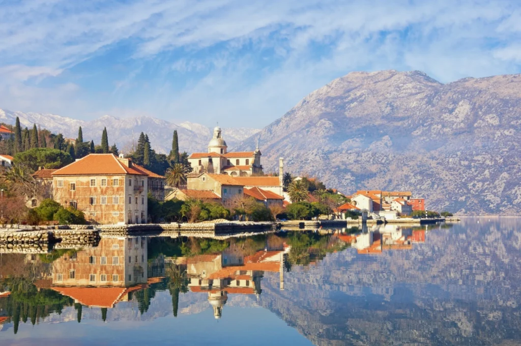 Luxury yacht cruising near Kotor, Montenegro, with dramatic Adriatic bay views, medieval town walls, and a picturesque coastline.