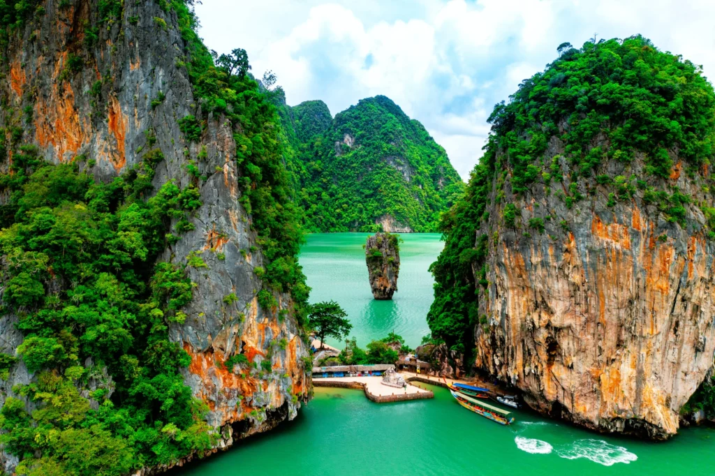 Luxury yacht cruising in Phang Nga Bay, Phuket, Thailand, with dramatic limestone karsts, crystal-clear waters, and stunning coastal scenery.