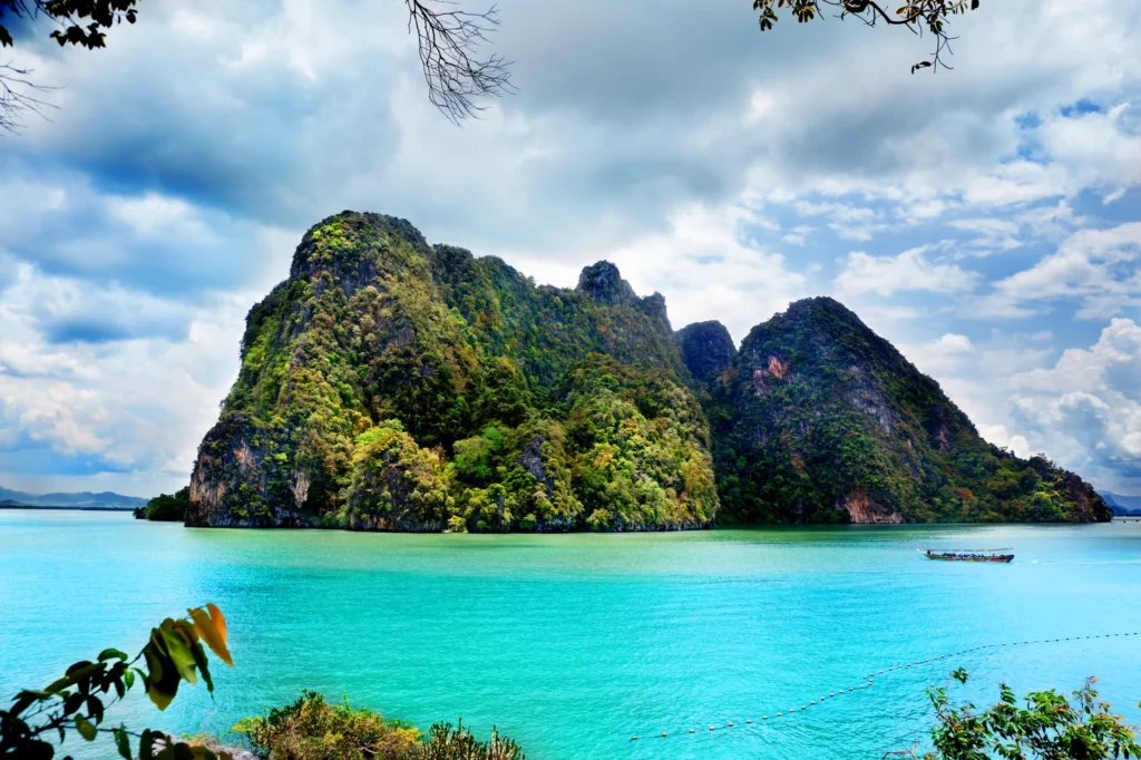 Luxury yacht cruising in Phang Nga Bay, Phuket, Thailand, with dramatic limestone karsts, crystal-clear waters, and stunning coastal scenery.
