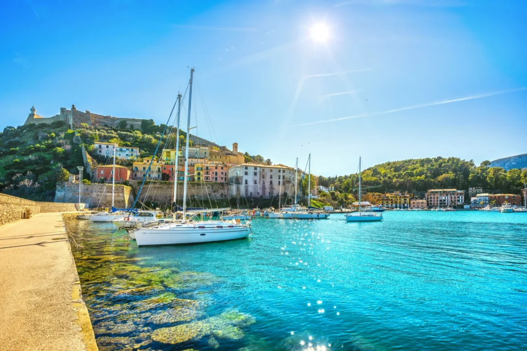 Luxury yacht cruising near Porto Ercole, Tuscany Coast, Italy, with clear blue waters, charming seaside villages, and scenic Mediterranean landscapes.