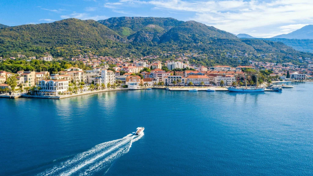 Luxury yacht cruising near Tivat, Montenegro, with clear Adriatic waters, sophisticated marinas, and stunning coastal views."