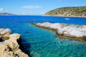 Luxury yacht sailing near Amorgos, Greece, with dramatic cliffs, whitewashed villages, and deep blue Aegean waters.