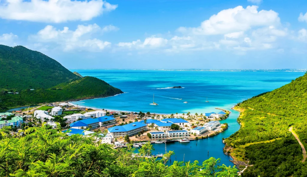 Luxury yacht anchored nearAnse de Marcel, St. Martin, with calm turquoise waters, lush green hills, and a peaceful beach cove.