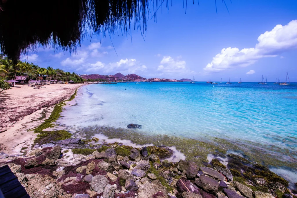 Luxury yacht anchored near Canouan in the Grenadines, with turquoise waters, white-sand beaches, and upscale island resorts.