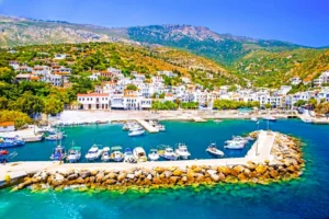 Luxury yacht cruising near Ikaria, Greece, with rugged coastline, clear Aegean waters, and untouched island scenery.