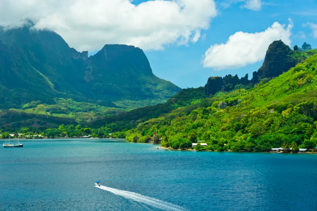 Luxury yacht anchored near Moorea, French Polynesia, with emerald peaks, turquoise lagoons, and palm-lined shores in the background.