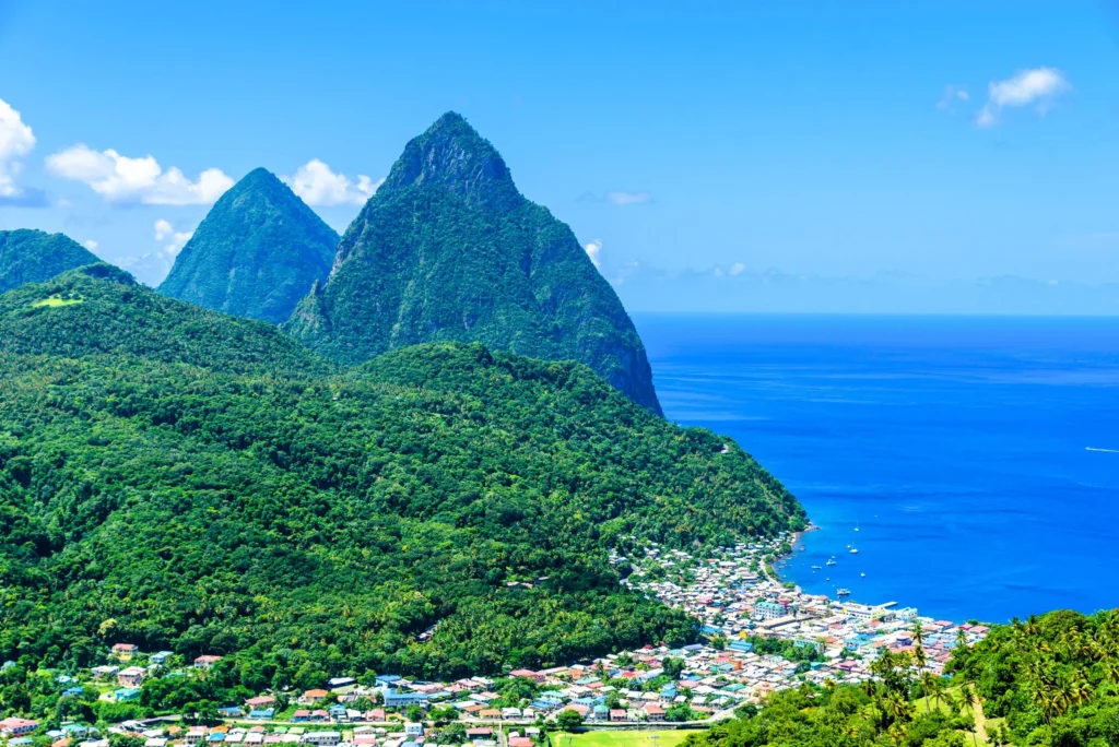 Luxury yacht sailing near St. Lucia, Caribbean, with the iconic Piton mountains, lush green landscapes, and sparkling turquoise waters in view.