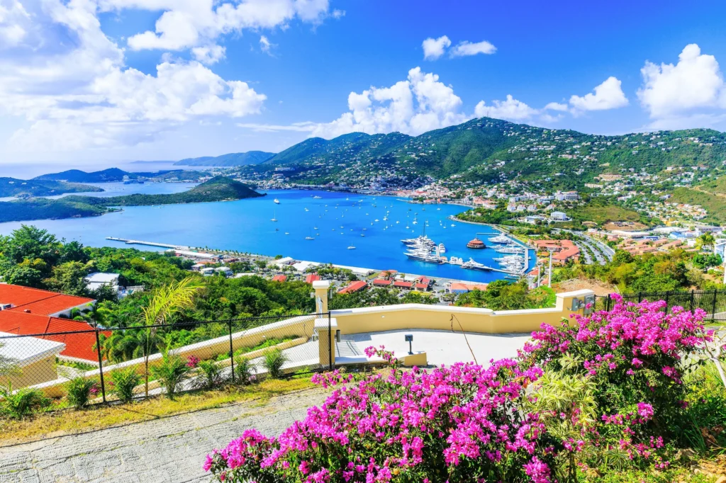 Luxury yacht anchored near St. Thomas, US Virgin Islands, with turquoise Caribbean waters, palm-lined beaches, and a vibrant coastal town in view.