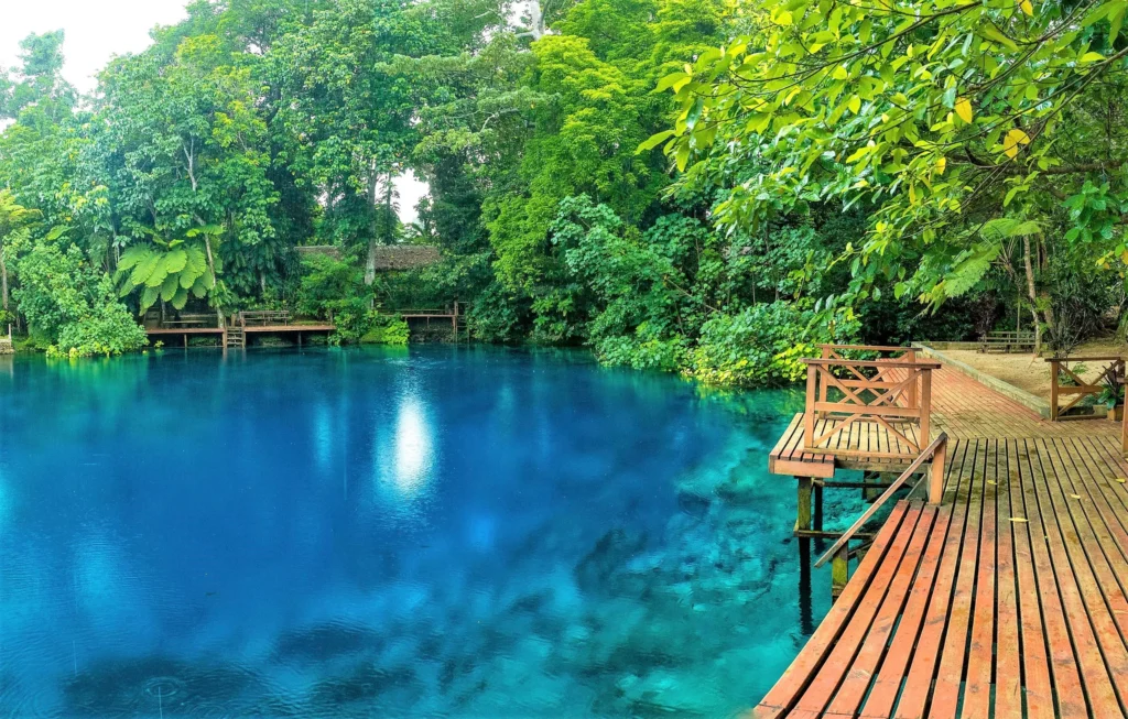 Luxury yacht anchored off the coast of Vanuatu, surrounded by volcanic islands, lush rainforests, and clear tropical waters